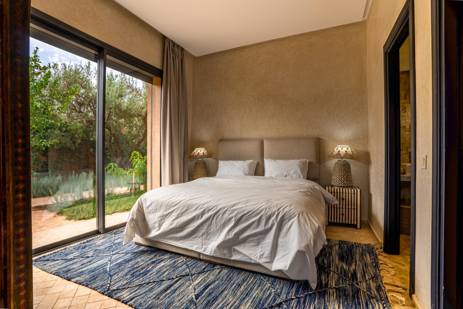 Suite Four: king-size bed with a glass wall opening onto the garden